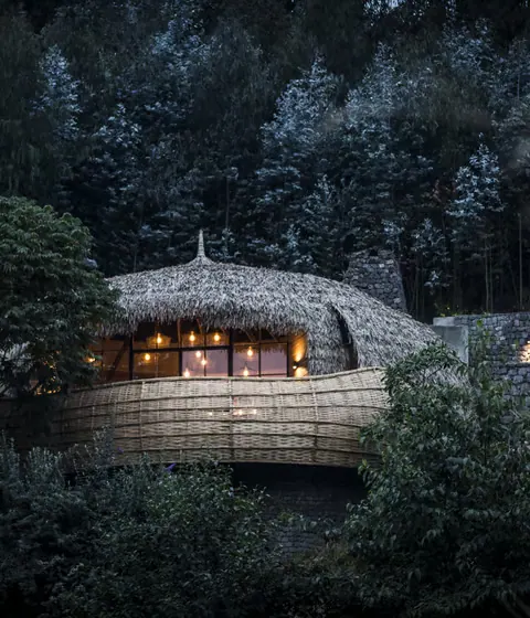 Thatched safari suite lit from within after dark